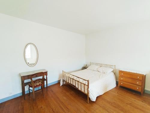 a bedroom with a bed and a dresser and a mirror at Gite La Tanière in Siradan