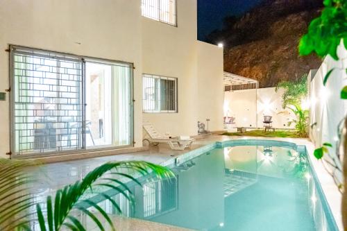 uma piscina em frente a uma casa em ELIVAAS Le Aravella 3 BHK Villa with Gazebo, Balcony & Private Pool em Lakāwās