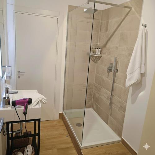 a bathroom with a glass shower with a sink at Etna Charme Guest House in Belpasso