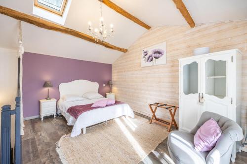 ein Schlafzimmer mit zwei Betten und einem Stuhl in der Unterkunft Le Clemenceau in Les Épesses