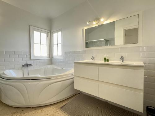 a white bathroom with a tub and a sink at Villa near the ocean with private pool and garage in San Miguel de Abona