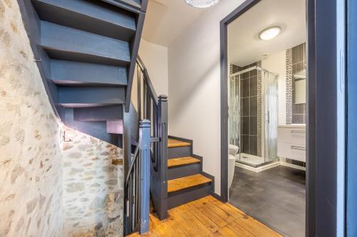 eine Treppe in einem Haus mit einer Steinmauer in der Unterkunft Le Clemenceau in Les Épesses