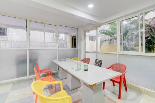 FabHotel RK Grand في حيدر أباد: طاولة وكراسي في غرفة بها نوافذ
