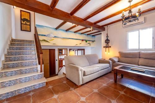 un soggiorno con un divano e una scala di Villa Marquesa - Punta Umbria a Punta Umbría