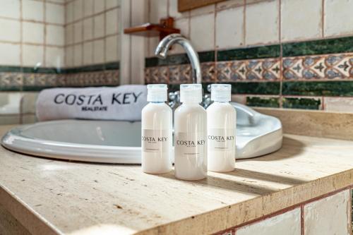 quattro bottiglie di latte appoggiate sul ripiano del bagno di Villa Marquesa - Punta Umbria a Punta Umbría