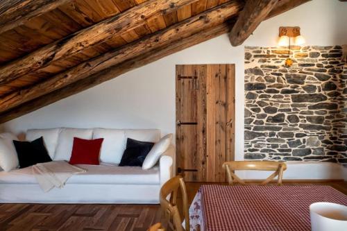sala de estar con sofá blanco y pared de piedra en Chalet Morge, en La Salle