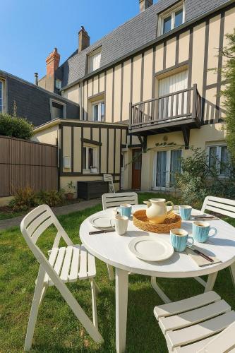 a white table and chairs in a yard at L'Acacia, F2 terrasse et jardin,plage à 400mètres in Houlgate