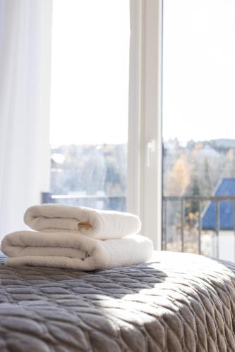 a pile of towels sitting on a bed with a window at Апартаменти Velvet Rooms in Skhidnitsa