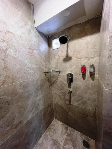 ein Badezimmer mit Dusche und Steinwand in der Unterkunft Hotel Yambu kathmandu in Kathmandu
