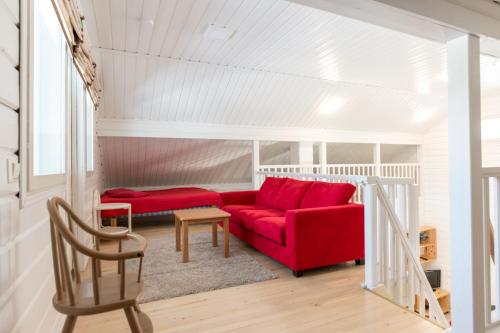 un soggiorno con divano rosso e sedia di Meriheinä a Kalajoki