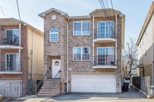 Lovely 3BR Home Quick Trip to NYC Prudential في نيوآرك: منزل من الطوب مع مرآب أبيض