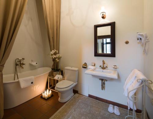 a bathroom with a tub and a toilet and a sink at Monte Pacis in Kaunas