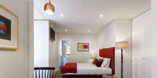 a bedroom with a white bed with a red blanket at LSA Bairro Alto by Numa in Lisbon