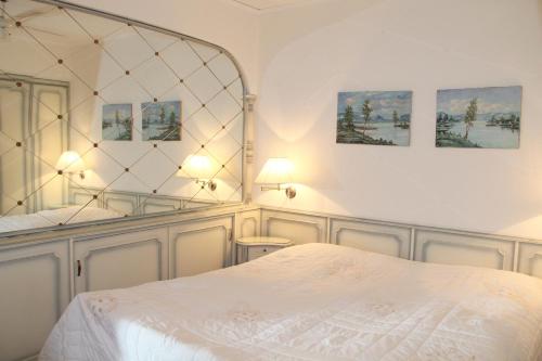 a bedroom with a white bed and a mirror at Barony Le Pergole Lugano - 2 persons in Lugano