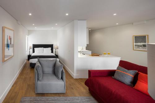 a living room with a red couch and a bed at LSA Bairro Alto by Numa in Lisbon