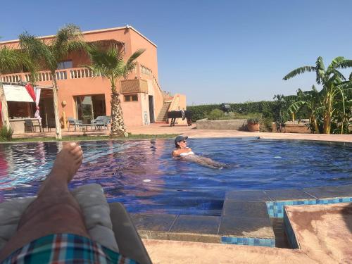 a person laying on a raft in a swimming pool at chez JM saida in Ourika