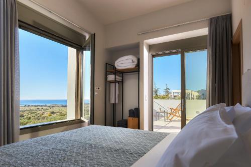 ein Schlafzimmer mit Bett und Blick auf das Meer in der Unterkunft Alba Lilia II in Pitsidia