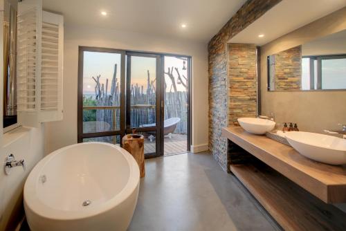 a bathroom with two sinks and a large window at Garden Route Game Lodge in Albertinia
