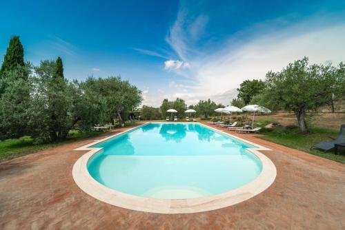 una grande piscina con sedie e ombrelloni di Santantimo Tuscany Inn ad Arezzo