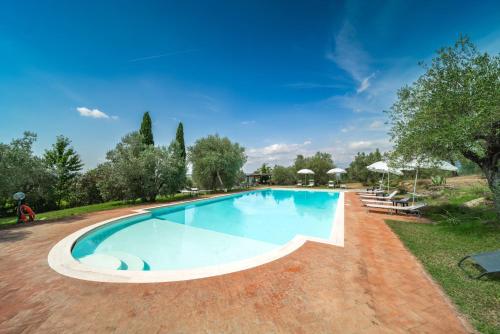 una grande piscina in un cortile alberato di Santantimo Tuscany Inn ad Arezzo