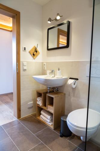 a bathroom with a sink and a toilet at Kaffeekandl Café & Pension in Glonn