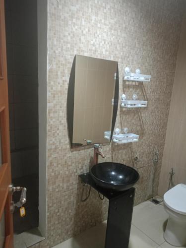 a bathroom with a black sink and a toilet at casavina studio 304 private kitchen, Near beach in Canggu