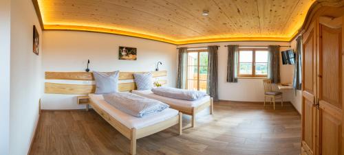 a bedroom with two beds and a wooden ceiling at Kaffeekandl Café & Pension in Glonn