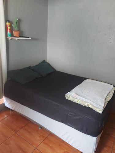 een klein bed in een hoek van een kamer bij Kitinete final de rua centro in Itajaí