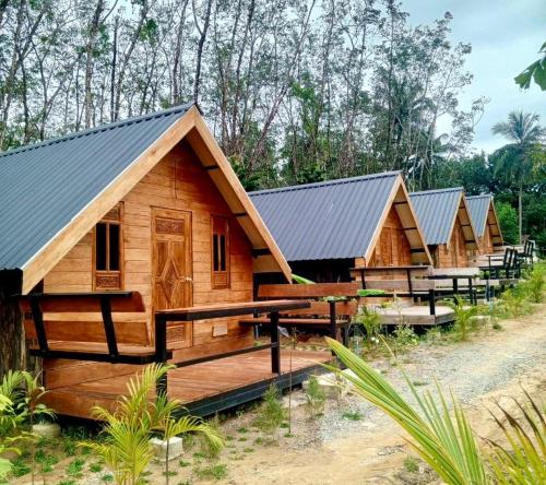 a row of wooden huts in a row at Phayam Paradise Resort in Ko Phayam