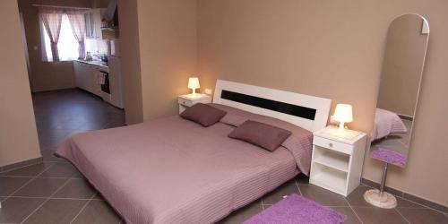 a bedroom with a large bed with two night stands at Federica A2+1 in Veli Lošinj