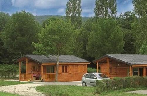 a log cabin with a car parked in front of it at ZEcamping 4 familial animaux acceptés avec piscine et soirées animées in Lons-le-Saunier