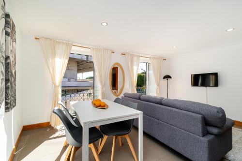 a living room with a couch and a table and chairs at Belém Cozy Apartments by Soulplaces in Lisbon