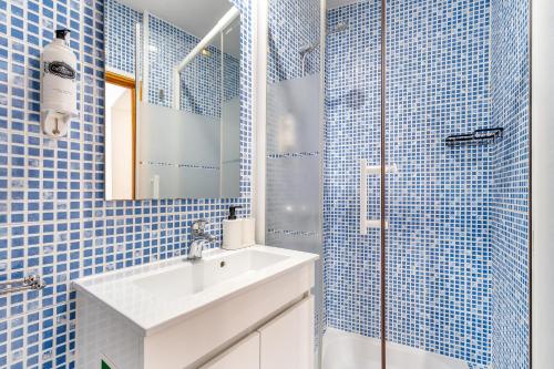 a bathroom with a sink and a shower with blue tiles at Belém Cozy Apartments by Soulplaces in Lisbon