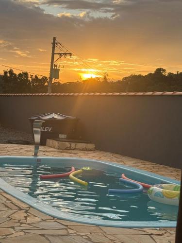 een zwembad met een zonsondergang op de achtergrond bij Recanto do entardecer in Socorro