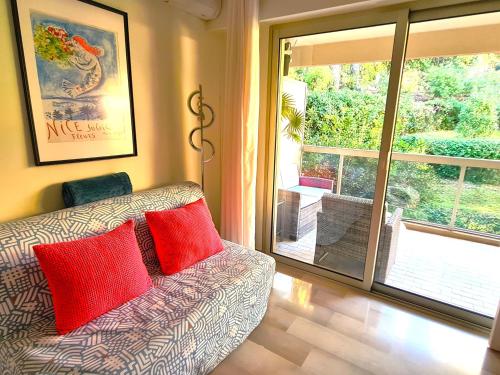 ein Wohnzimmer mit Couch und großem Fenster in der Unterkunft Studio grande terrasse à 5 min de la mer in Nizza