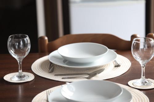 a wooden table with white plates and wine glasses at Mercury Yacht Harbour and Holiday Park in Bursledon