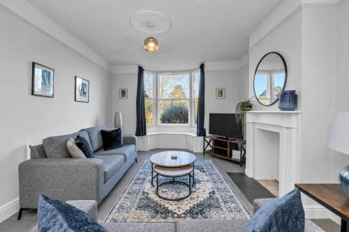 a living room with a couch and a table at 17 OutRisbygate St - 3 bedroom house that sleeps 6 with one private parking space in Bury Saint Edmunds