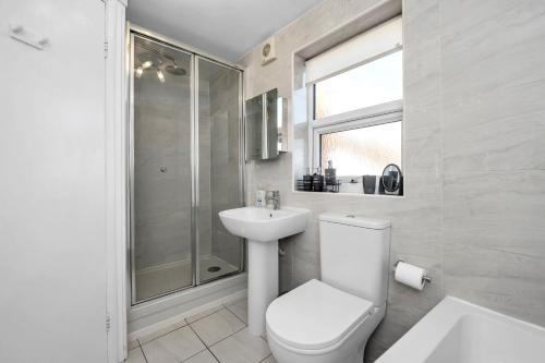 a bathroom with a toilet and a sink and a shower at 17 OutRisbygate St - 3 bedroom house that sleeps 6 with one private parking space in Bury Saint Edmunds