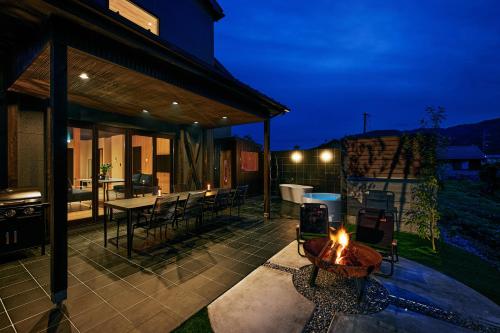 an outdoor patio with a fire pit and a table at SUITE VILLA 惺 - shou - in Takashima