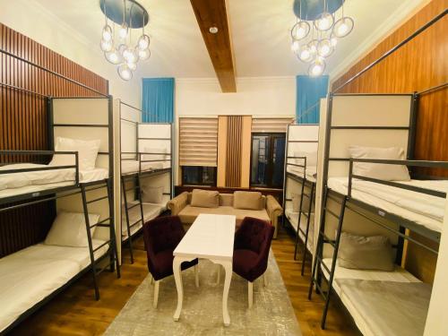 ein Zimmer mit Etagenbetten und einem Tisch und Stühlen in der Unterkunft TURQUOISE Hostel in Bukarest