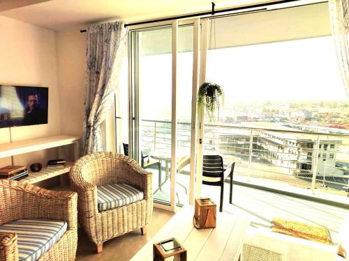 a living room with a couch and chairs and a large window at 404 Horizon Bay in Bloubergstrand