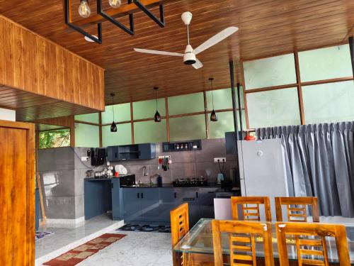eine Küche mit Tisch und Stühlen und einem Kühlschrank in der Unterkunft Retreat Rivera where Serenity Meets the River in Green Island
