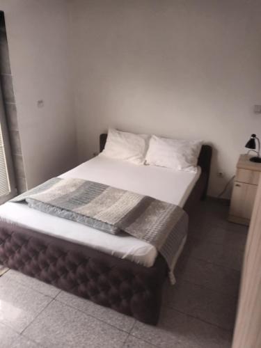 ein Bett mit weißen Laken und Kissen in einem Zimmer in der Unterkunft Blu point 1 in Kragujevac