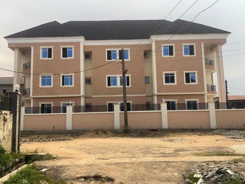 a large building with a fence in front of it at RegisVille Hotel in Magboro