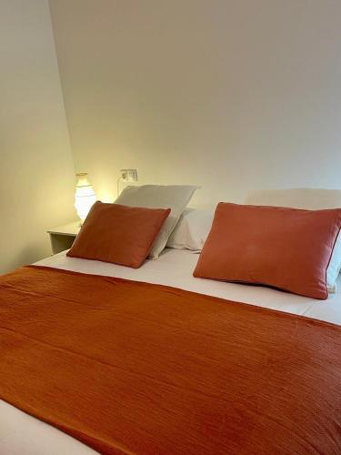 a bed with two orange pillows on top of it at Oasis Rural in Ucero