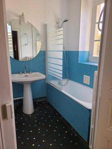 a blue tiled bathroom with a sink and a shower at La maison du régisseur in Chauvigny