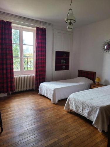 a bedroom with two beds and a window at La maison du régisseur in Chauvigny