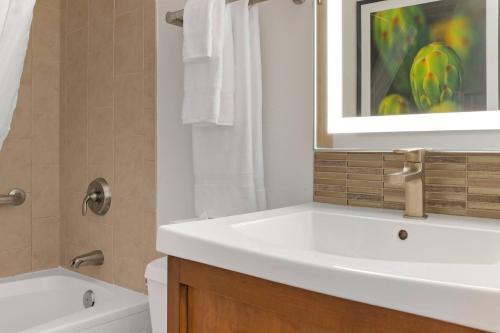 bagno con lavandino bianco e vasca di Desert Rose Resort a Las Vegas