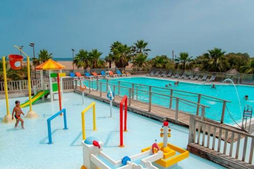 a pool at a resort with people playing in it at ZEcamping 4 étoiles chiens acceptés piscine chauffée et toboggans in Portiragnes