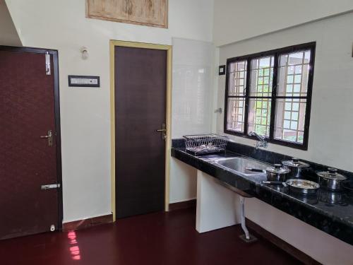 a kitchen with a sink and a window at The Sparrow House 1BHK First Floor in Kumbakonam